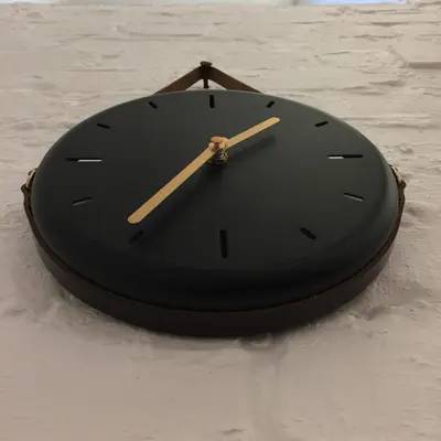 a black clock is sitting on the snow at Jolie Apartments in Kaunas