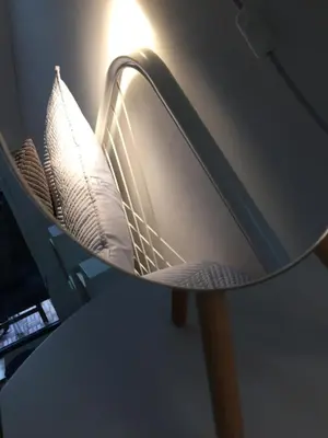 a shelf with a mirror on a desk at Jolie Apartments in Kaunas