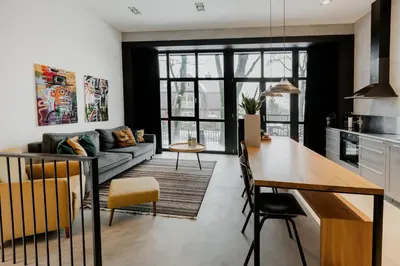 a kitchen and living room with a couch and a table at Modern and spacious loft type apartment 8 with free private parking by 