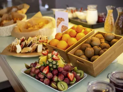 a table topped with plates of different types of fruit at Ibis Kaunas Centre in Kaunas
