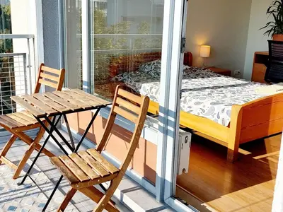 a room with a bed and two chairs on a balcony at New apartament very close to the city centre in Vilnius
