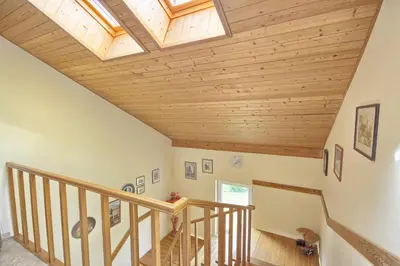 an attic staircase with a skylight and wooden ceilings at Poilsis Pas Tada in Druskininkai