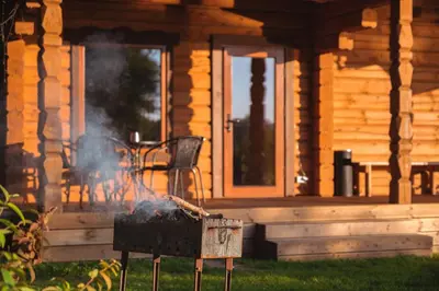 a grill in front of a wooden house at House of Sparkles in Elektrėnai