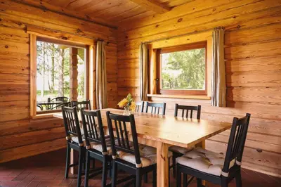 a wooden dining room with a wooden table and chairs at House of Sparkles in Elektrėnai