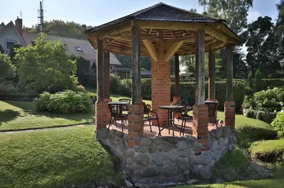 a gazebo with a table and chairs in a yard at Ašmonienės svečių namai 