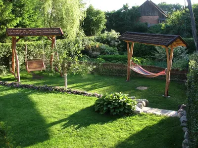 a garden with a hammock and a gazebo at Ašmonienės svečių namai 
