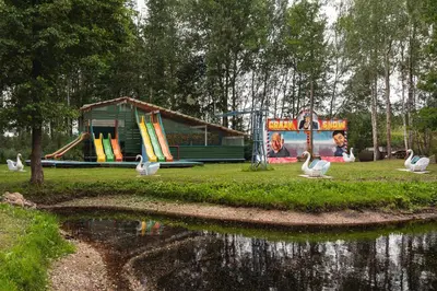 a park with a playground with a slide and swans at Senelio Romo Sodyba in Molėtai