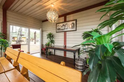 a bench in a room with a table and potted plants at Senelio Romo Sodyba in Molėtai