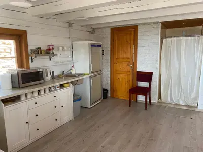 a kitchen with white appliances and a wooden floor at Senelio Romo Sodyba in Molėtai