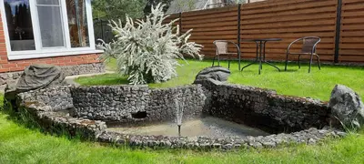 a stone fountain in the yard of a house at Verkių Namelis in Vilnius