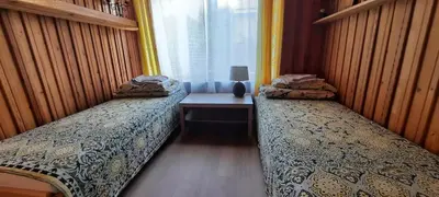 two beds in a small room with a window at Verkių Namelis in Vilnius