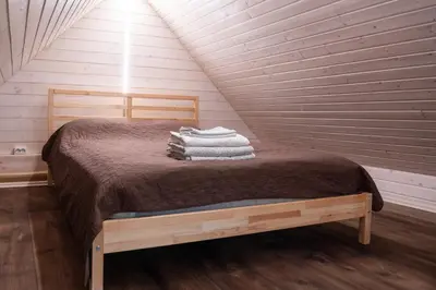 a bedroom with a bed with towels on it at Sodyba Namelis medyje Anykščiuose in Anykščiai