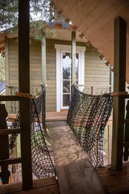 a porch with a hammock on a house at Sodyba Namelis medyje Anykščiuose in Anykščiai
