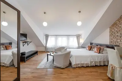 a attic bedroom with a bed and a mirror at Stepono apartments in Vilnius