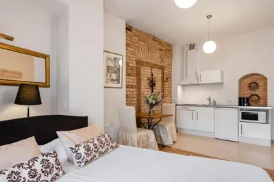 a living room with a bed and a kitchen at Stepono apartments in Vilnius