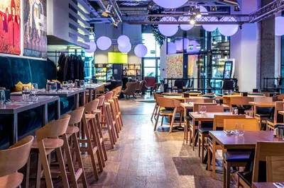 a restaurant with wooden tables and chairs at Comfort Hotel LT - Rock 'n' Roll Vilnius in Vilnius