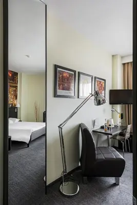 a bedroom with a bed and a desk and a lamp at Comfort Hotel LT - Rock 'n' Roll Vilnius in Vilnius