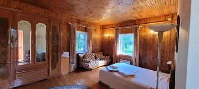a bedroom with a bed and a chair in a room at Sodyba Dubinga in Molėtai