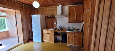 a kitchen with a white refrigerator and wooden cabinets at Sodyba Dubinga in Molėtai