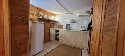 a kitchen with wooden walls and a white refrigerator at Sodyba Dubinga in Molėtai