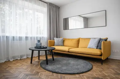 a living room with a yellow couch and a table at The Central Spot in Šiauliai
