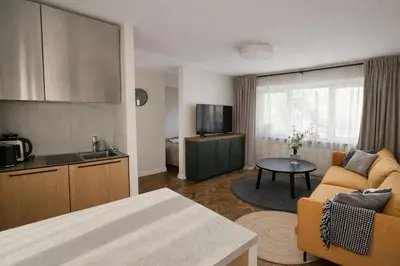 a kitchen and living room with a couch and a table at The Central Spot in Šiauliai