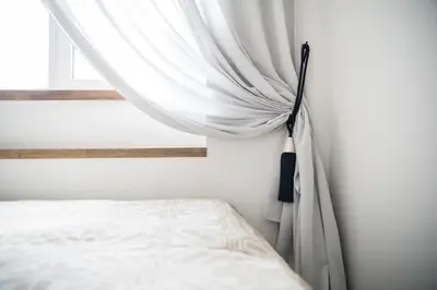 a bedroom with a bed and a curtain at The Central Spot in Šiauliai