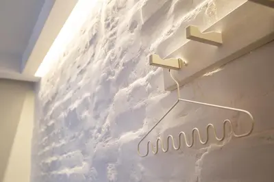 a white wall with a metal hook on it at The Central Spot in Šiauliai