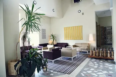 a living room with couches and plants at Nykščio Namai & SPA in Anykščiai