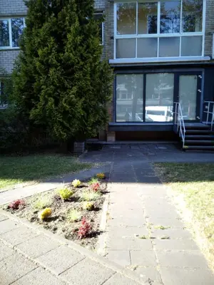 a garden in front of a house with flowers at Anykštukas in Anykščiai