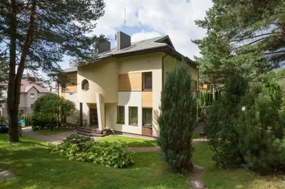 a white house with trees in the yard at Domina in Vilnius