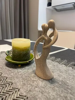 a couple of sculptures next to a cup on a table at New apartments for your stay in Vilnius in Vilnius