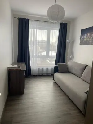 a living room with a couch and a large window at New apartments for your stay in Vilnius in Vilnius