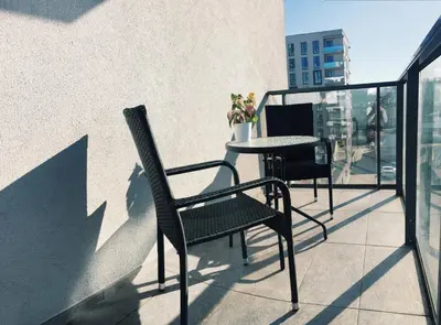 a balcony with a table and chairs on a building at New apartments for your stay in Vilnius in Vilnius