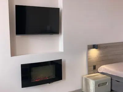 a living room with a fireplace with a tv above it at Sweet Apartments in Šiauliai
