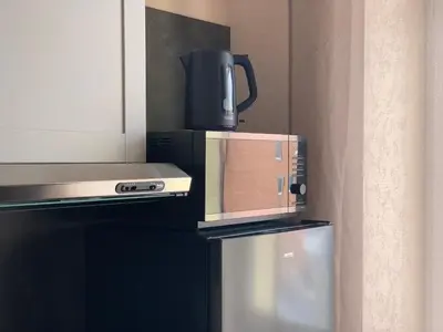 a coffee maker is sitting on top of a refrigerator at Sweet Apartments in Šiauliai