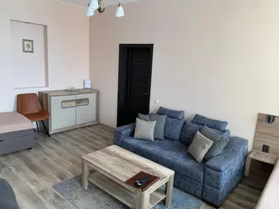 a living room with a blue couch and a table at Sweet Apartments in Šiauliai