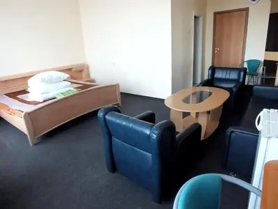 a room with a bed and a table and chairs at Motelis Jonučiai in Garliava