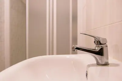 a sink with a faucet in a bathroom at Motelis Jonučiai in Garliava