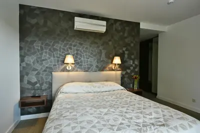 a bedroom with a bed and two lamps on the wall at 