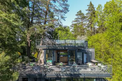 a glass house in the middle of a forest at 