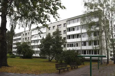 a large white building with benches in front of it at Relax Inn Druskininkai in Druskininkai