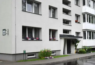 a white building with flowers in windows at Relax Inn Druskininkai in Druskininkai