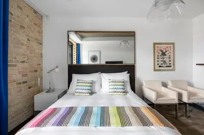 a bedroom with a bed and a brick wall at The Joseph in Vilnius