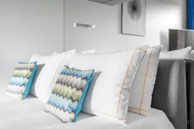 a white couch with four pillows on it at The Joseph in Vilnius