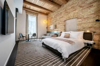 a bedroom with a large bed and a brick wall at The Joseph in Vilnius