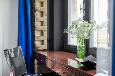 a vase of flowers on a table in a room at The Joseph in Vilnius