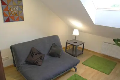 a living room with a couch and a table with a lamp at Nemunas Street Apartment in Kaunas