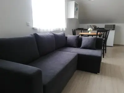 a living room with a blue couch and a table at Atostogų namai in Druskininkai