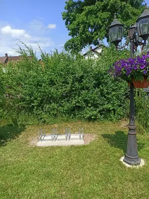 a park bench next to a light pole with flowers at Atostogų namai in Druskininkai